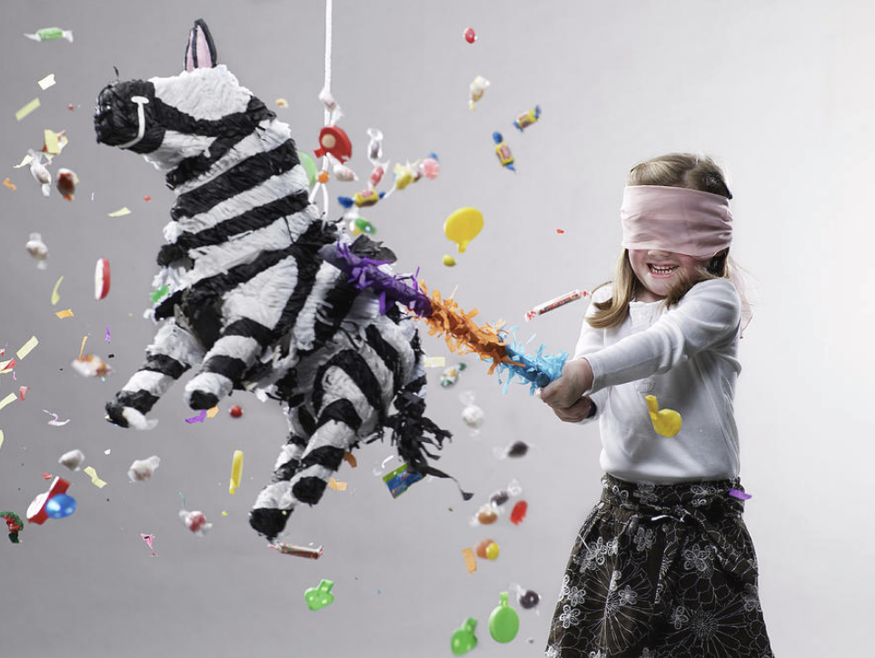 Little girl blindfolded hitting a zebra pinata from partytime in hong kong