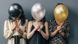 3 females covering their faces with balloons from Partytime shop